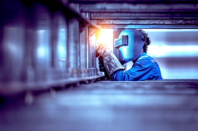 Industrial Worker labourer at the factory welding steel structure